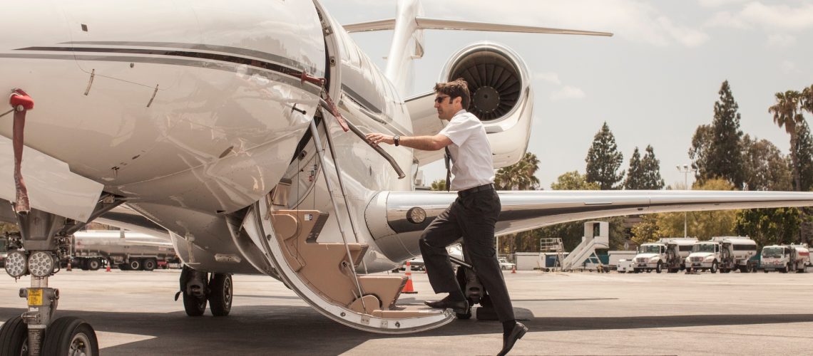 Male private jet pilot boarding plane at airport